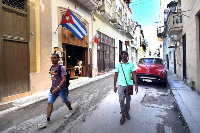 (251030) -- HAVANA, Oct. 30, 2025 (Xinhua) -- Two men walk along a street in Havana, capital of Cuba, on Oct. 29, 2025. The UN General Assembly (UNGA) adopted a draft resolution on Wednesday urging the United States to end its economic, commercial and financial embargo against Cuba. Since 1992, the UNGA has adopted by an overwhelming majority the non-binding annual resolution, urging the United States to end its embargo against Cuba imposed since 1962. (Photo by Joaquin Hernandez/Xinhua)