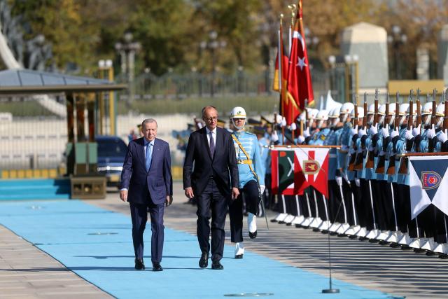 (251030) -- ANKARA, Oct. 30, 2025 (Xinhua) -- Turkish President Recep Tayyip Erdogan (L) and visiting German Chancellor Friedrich Merz review the guards of honor during a welcoming ceremony in Ankara, Türkiye, Oct. 30, 2025. (Mustafa Kaya/Handout via Xinhua)