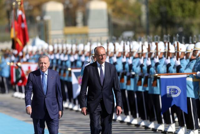 (251030) -- ANKARA, Oct. 30, 2025 (Xinhua) -- Turkish President Recep Tayyip Erdogan (L) and visiting German Chancellor Friedrich Merz review the guards of honor during a welcoming ceremony in Ankara, Türkiye, Oct. 30, 2025. (Mustafa Kaya/Handout via Xinhua)