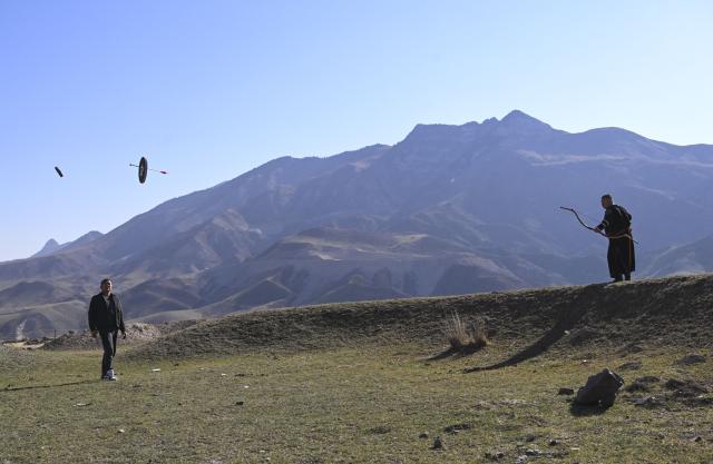 (251031) -- QAPQAL, Oct. 31, 2025 (Xinhua) -- Wu Junliang is a 37-year-old archer from Qapqal Xibe Autonomous County, a border county in northwest China's Xinjiang Uygur Autonomous Region - also proudly known as the hometown of Chinese archery. Wu is a recognized inheritor of the national intangible cultural heritage "Traditional Xibe Archery" and he has joined the "heritage-in-schools" initiative, offering free archery training to primary school students. He is called the "champion coach" by students.
Recognized for his strong arms and steady composure, Wu was admitted to a local archery school at the age of 16 to receive professional training. With outstanding talent, he quickly emerged, winning gold and silver medals in competitions at various levels. After retiring, he was hired as an archery coach for visitors at the Xibe Ancient Town.
For over a decade, Wu further studied traditional bows and taught himself multiple skills including horseback archery and rapid shooting at moving targets. As traditional bow competitions increased, he participated nationwide, winning multiple championships and training a number of apprentices. 
As intangible-heritage tourism gains popularity in recent years, Wu opened a 300-square-meter archery club in Yining City earlier this year, highlighting traditional bow culture. Wu Junliang (R) shoots at a target on a hill in Qapqal Xibe Autonomous County, northwest China's Xinjiang Uygur Autonomous Region, on Oct. 24, 2025. (Xinhua/Hu Huhu)
