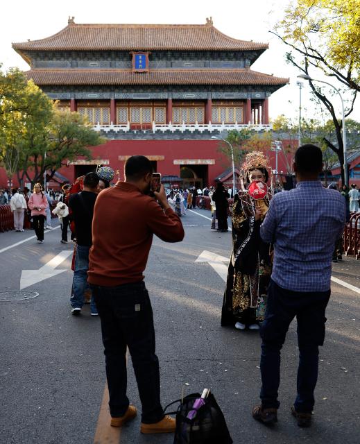 (251101) -- BEIJING, Nov. 1, 2025 (Xinhua) -- Ethiopian tourist Betty (2nd R) wearing traditional Chinese costumes enjoys her photoshoot experience outside Donghua Gate, as known as East Prosperity Gate of the Palace Museum in Beijing, capital of China, Nov. 1, 2025. From January to September 2025, Beijing has received approximately 3.88 million inbound tourists, a year-on-year increase of 42.9 percent, according to Beijing Municipal Bureau of Culture and Tourism. (Xinhua/Wang Lili)