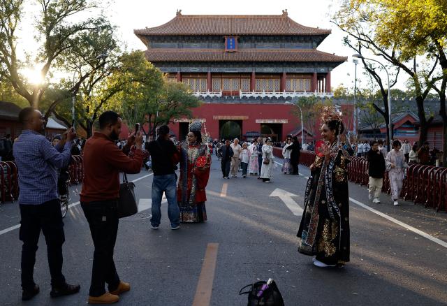 (251101) -- BEIJING, Nov. 1, 2025 (Xinhua) -- Ethiopian tourists Nuni (4th L, front ) and Betty(1st R, front) wearing traditional Chinese costumes enjoy their photoshoot experience outside Donghua Gate, as known as East Prosperity Gate of the Palace Museum in Beijing, capital of China, Nov. 1, 2025. From January to September 2025, Beijing has received approximately 3.88 million inbound tourists, a year-on-year increase of 42.9 percent, according to Beijing Municipal Bureau of Culture and Tourism. (Xinhua/Wang Lili)