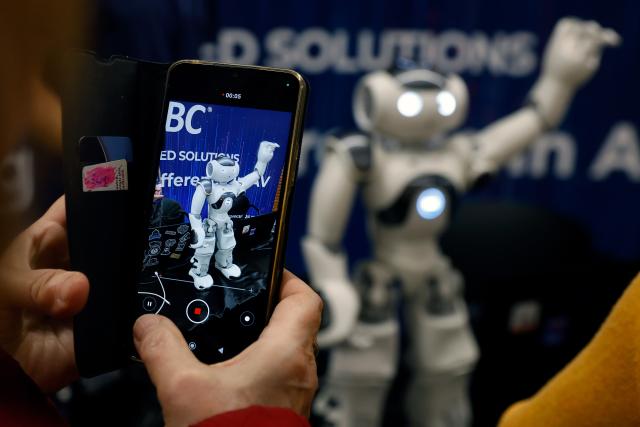(251102) -- BUCHAREST, Nov. 2, 2025 (Xinhua) -- A visitor takes pictures of a humanoid robot during the 4th edition of the Robofest, a technology festival, at the Politehnica University of Bucharest in Bucharest, Romania, Nov. 1, 2025. The three-day festival including the 16th edition of the Robochallenge is held here from Oct. 31 to Nov. 2. (Photo by Cristian Cristel/Xinhua)