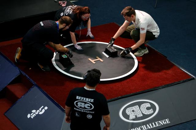 (251102) -- BUCHAREST, Nov. 2, 2025 (Xinhua) -- Participants place their robots for a Sumo contest during the 4th edition of the Robofest, a technology festival, at the Politehnica University of Bucharest in Bucharest, Romania, Nov. 1, 2025. The three-day festival including the 16th edition of the Robochallenge is held here from Oct. 31 to Nov. 2. (Photo by Cristian Cristel/Xinhua)