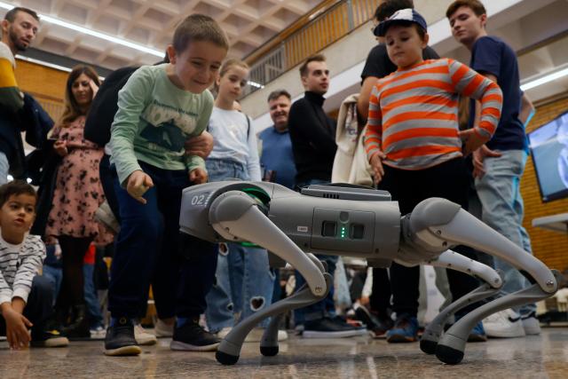 (251102) -- BUCHAREST, Nov. 2, 2025 (Xinhua) -- Children look at a robotic dog during the 4th edition of the Robofest, a technology festival, at the Politehnica University of Bucharest in Bucharest, Romania, Nov. 1, 2025. The three-day festival including the 16th edition of the Robochallenge is held here from Oct. 31 to Nov. 2. (Photo by Cristian Cristel/Xinhua)