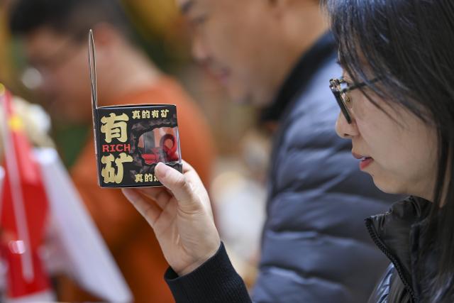 (251102) -- TAIYUAN, Nov. 2, 2025 (Xinhua) -- A visitor looks at a product in a shop at Zhonglou Street in Taiyuan, north China's Shanxi Province, Oct. 29, 2025. As both a commercial hub and cultural landmark of Taiyuan, Zhonglou Street carries a millennium of local history. However, rapid urban development once left it struggling with aging facilities, narrow spaces, and traffic congestion.
     In 2020, Taiyuan launched a renovation project for the area, and by September of 2021, the historic street renewed with a fresh look. The upgrade preserved the traditional street layout and architectural style while integrating modern elements and functions, attracting numerous locals and tourists daily.
    In 2022, Zhonglou Street was listed among the second batch of national nighttime cultural and tourism consumption clusters. In 2023, it was included in the second batch of national-level tourism and leisure blocks. During this year's National Day holiday, nearly 900,000 visits were made to the street, cementing its status as a true "city living room." (Xinhua/Yang Chenguang)