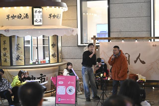 (251102) -- TAIYUAN, Nov. 2, 2025 (Xinhua) -- Two men sing at Zhonglou Street in Taiyuan, north China's Shanxi Province, Oct. 29, 2025. As both a commercial hub and cultural landmark of Taiyuan, Zhonglou Street carries a millennium of local history. However, rapid urban development once left it struggling with aging facilities, narrow spaces, and traffic congestion.
     In 2020, Taiyuan launched a renovation project for the area, and by September of 2021, the historic street renewed with a fresh look. The upgrade preserved the traditional street layout and architectural style while integrating modern elements and functions, attracting numerous locals and tourists daily.
    In 2022, Zhonglou Street was listed among the second batch of national nighttime cultural and tourism consumption clusters. In 2023, it was included in the second batch of national-level tourism and leisure blocks. During this year's National Day holiday, nearly 900,000 visits were made to the street, cementing its status as a true "city living room." (Xinhua/Yang Chenguang)