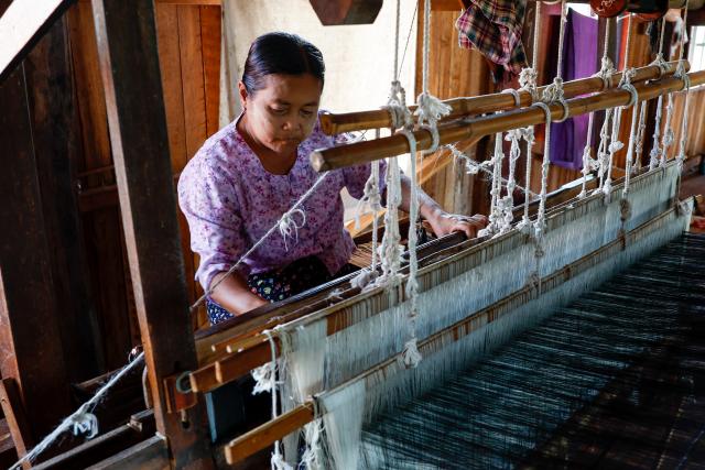 (251102) -- YANGON, Nov. 2, 2025 (Xinhua) -- A woman weaves on a traditional loom at a hand-weaving workshop on Inle Lake in Nyaungshwe township, Shan state, Myanmar, Oct. 31, 2025. TO GO WITH "Feature: With patient hands, Myanmar's Inthas weave lotus fibers into world's handcrafted luxury" (Xinhua/Myo Kyaw Soe)