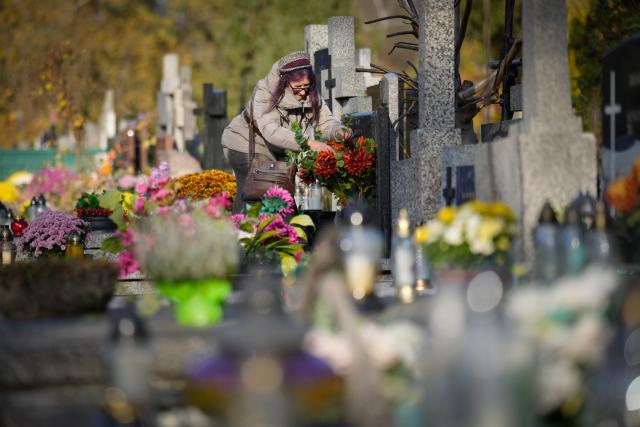 (251103) -- BEIJING, Nov. 3, 2025 (Xinhua) -- A woman arranges flowers on a grave to commemorate All Saints' Day at a cemetery in Warsaw, Poland on Nov. 1, 2025.
  Saturday marks All Saints' Day in Poland, when people traditionally return home to reunite with family members and visit cemeteries to honor their ancestors. (Photo by Jaap Arriens/Xinhua)