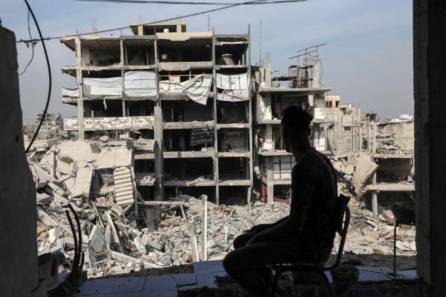 (251103) -- GAZA, Nov. 3, 2025 (Xinhua) -- A Palestinian sits in a destroyed building in the Jabalia refugee camp in northern Gaza on Nov. 2, 2025. (Photo by Rizek Abdeljawad/Xinhua)