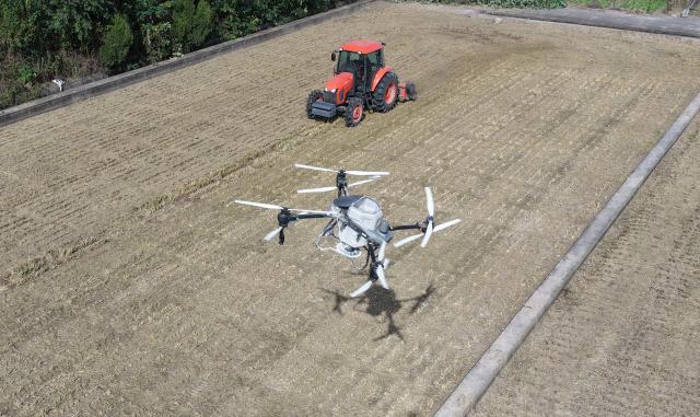 (251103) -- BEIJING, Nov. 3, 2025 (Xinhua) -- An aerial drone photo shows a drone spraying fertilizer in a field in Yanghzou City, east China's Jiangsu Province, Nov. 3, 2025. As of October 30, over 90% of the autumn grain have been harvested and over 25% of the winter wheat have been sowed across the country. (Photo by Meng Delong/Xinhua)