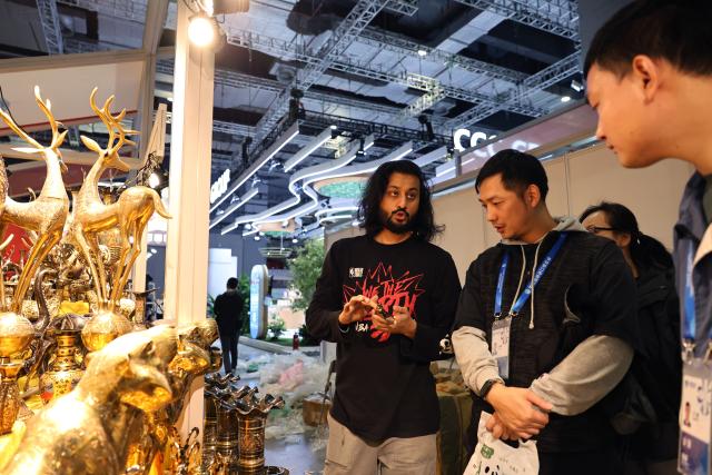 (251103) -- SHANGHAI, Nov. 3, 2025 (Xinhua) -- A Pakistani merchant (L) talks to staff members while preparing for the upcoming eighth China International Import Expo (CIIE) in Shanghai, east China, Nov. 3, 2025. The eighth CIIE will be held in Shanghai from Nov. 5 to 10. The event this year will feature 4,108 overseas exhibitors from 155 countries, regions and international organizations, with the total exhibition area exceeding 430,000 square meters, setting a new record in scale. (Xinhua/Fang Zhe)