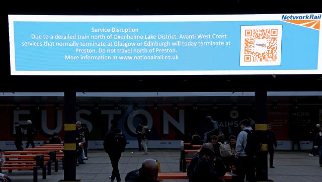 (251103) -- LONDON, Nov. 3, 2025 (Xinhua) -- People wait for trains below a screen showing information on changes to rail services at Euston Station in London, Britain, Nov. 3, 2025. A train carrying 87 people derailed in northwestern England on Monday, disrupting rail services, local media reported. (Xinhua/Li Ying)