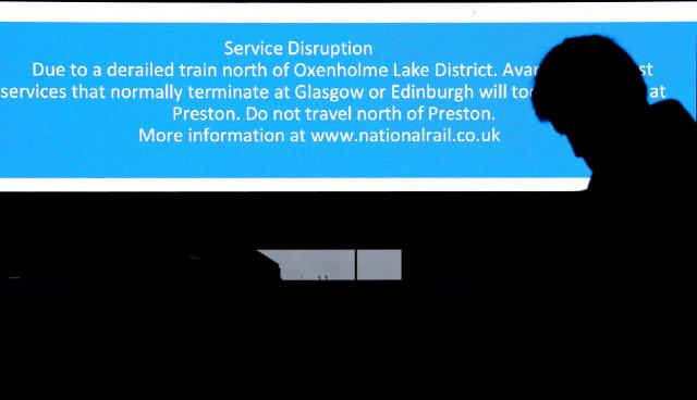 (251103) -- LONDON, Nov. 3, 2025 (Xinhua) -- A man stands next to a screen showing information on changes to rail services at Euston Station in London, Britain, Nov. 3, 2025. A train carrying 87 people derailed in northwestern England on Monday, disrupting rail services, local media reported. (Xinhua/Li Ying)