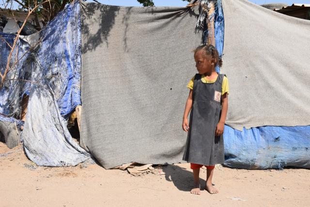 (251103) -- ADEN(YEMEN), Nov. 3, 2025 (Xinhua) -- A displaced girl stands near her family's makeshift shelter, made from blankets and tarps, at a camp on the outskirts of Aden, Yemen, Nov. 3, 2025. TO GO WITH "Feature: Bitter cold, tattered tents -- displaced Yemenis brace for harsher winter" (Photo by Murad/Xinhua)
