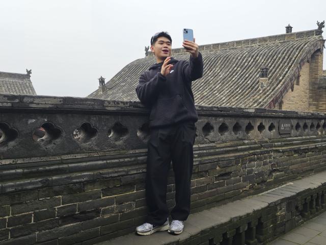 (251104) -- TAIYUAN, Nov. 4, 2025 (Xinhua) -- Veldesen Yaputra shoots a video at the Wang Family Courtyard in Lingshi County, north China's Shanxi Province, Oct. 16, 2025.
  TO GO WITH "Feature: A Chinese-Indonesian student's architectural pursuit" (Xinhua/Li Yuanhao)
