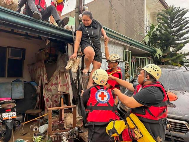 (251104) -- CEBU, Nov. 4, 2025 (Xinhua) -- Rescuers from the Philippine Red Cross evacuate residents from their home after the flood brought by heavy rains from typhoon Kalmaegi in Cebu Province, the Philippines, on Nov. 4, 2025. Typhoon Kalmaegi has hammered the Philippines overnight on Monday, killing at least one and affecting nearly 60,000 people in the central and southern Philippines, the National Disaster Risk Reduction and Management Council (NDRRMC) said on Tuesday. (Philippine Red Cross /Handout via Xinhua)