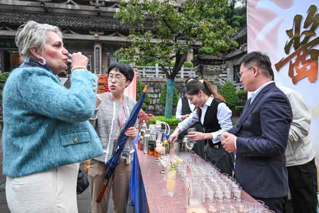 (251104) -- GUIYANG, Nov. 4, 2025 (Xinhua) -- A foreign guest (1st L) tastes a kind of local liquor in Maotai Town, Renhuai City, southwest China's Guizhou Province, Oct. 29, 2025. TO GO WITH "China Focus: China's traditional liquor brewing industry embraces digital transformation" (Xinhua/Yang Wenbin)