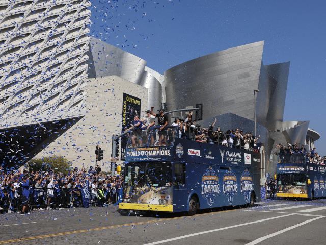 (251104) -- LOS ANGELES, Nov. 4, 2025 (Xinhua) -- Fans cheer as buses carrying players of Los Angeles Dodgers passing by during the Los Angeles Dodgers' victory parade in Los Angeles, California, the United States, on Nov. 3, 2025. On Saturday, the Dodgers clinched the 2025 MLB World Series title with a victory over the Toronto Blue Jays. (Photo by Qiu Chen/Xinhua)