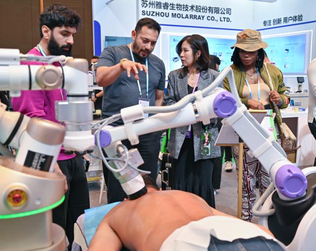 (251104) -- GUANGZHOU, Nov. 4, 2025 (Xinhua) -- Buyers learn about a physical therapy robot during the 138th edition of the China Import and Export Fair in Guangzhou, south China's Guangdong Province, Nov. 3, 2025. The 138th Canton Fair, known officially as the China Import and Export Fair, came to a close on Tuesday in Guangzhou, the capital city of south China's Guangdong Province, having seen a record number of overseas buyers attend. (Xinhua/Xiao Ennan)