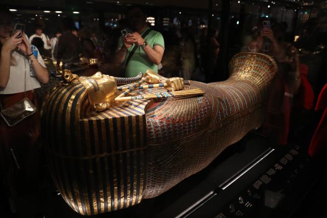 (251104) -- CAIRO, Nov. 4, 2025 (Xinhua) -- Tourists view a gilded coffin at the King Tutankhamun exhibition hall of the Grand Egyptian Museum in Giza, Egypt, on Nov. 4, 2025. The Grand Egyptian Museum (GEM) , the world's largest museum dedicated to a single civilization, opened to the public on Tuesday. (Xinhua/Sui Xiankai)