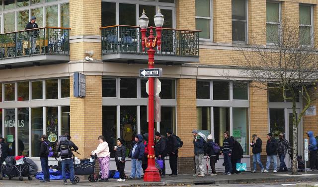 (251104) -- PORTLAND, Nov. 4, 2025 (Xinhua) -- People are seen waiting to receive free food on the street in Portland, Oregon, the United States, Nov. 4, 2025. The U.S. Senate on Tuesday again failed to pass a temporary funding bill, marking the 14th unsuccessful attempt. This means the federal government shutdown is on track to surpass the 35-day record set during the 2018-2019 shutdown and become the longest in U.S. history. (Xinhua/Wu Xiaoling)