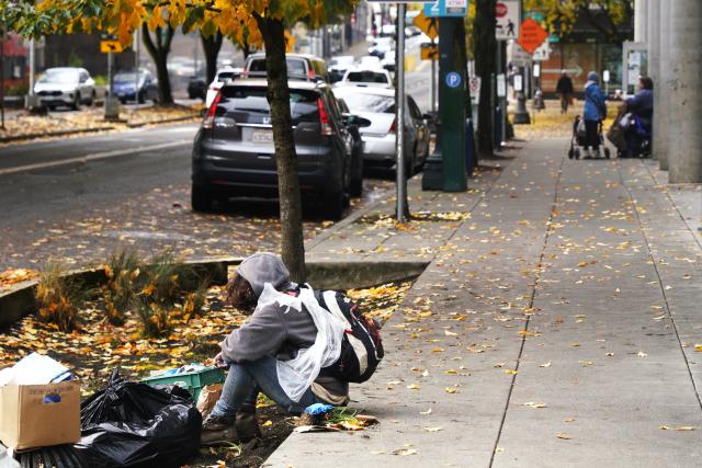 (251104) -- PORTLAND, Nov. 4, 2025 (Xinhua) -- A homeless person is seen sitting on the sidewalk in Portland, Oregon, the United States, Nov. 4, 2025. The U.S. Senate on Tuesday again failed to pass a temporary funding bill, marking the 14th unsuccessful attempt. This means the federal government shutdown is on track to surpass the 35-day record set during the 2018-2019 shutdown and become the longest in U.S. history. (Xinhua/Wu Xiaoling)