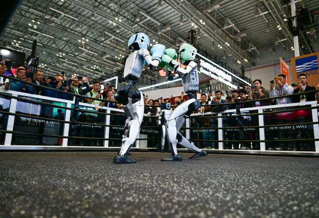 (251106) -- SHANGHAI, Nov. 6, 2025 (Xinhua) -- Two humanoid robots perform a session of fighting at civilian robotics company Unitree's booth during the China International Import Expo (CIIE) in east China's Shanghai, Nov. 6, 2025. Straight punches, hook punches, left and right side kicks...the fighting session, staged by two G1 humanoid robots wearing helmets and boxing gloves at the booth of Unitree here on Thursday, attracted lots of visitors and won rounds of applause. (Xinhua/Cai Xiangxin)