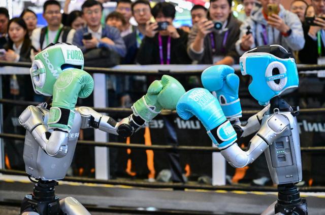 (251106) -- SHANGHAI, Nov. 6, 2025 (Xinhua) -- Two humanoid robots perform a session of fighting at civilian robotics company Unitree's booth during the China International Import Expo (CIIE) in east China's Shanghai, Nov. 6, 2025. Straight punches, hook punches, left and right side kicks...the fighting session, staged by two G1 humanoid robots wearing helmets and boxing gloves at the booth of Unitree here on Thursday, attracted lots of visitors and won rounds of applause. (Xinhua/Cai Xiangxin)