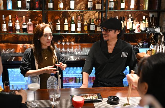 (251106) -- HAIKOU, Nov. 6, 2025 (Xinhua) -- Japanese restaurateur Kato Tetsuya (R) and his wife chat with diners at his bistro in Haikou, capital of south China's Hainan Province, Oct. 24, 2025. TO GO WITH "Across China: Japanese restaurateur pursues entrepreneurial dream in Hainan Free Trade Port" (Xinhua/Guo Cheng)