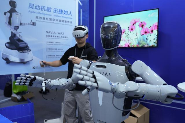 (251106) -- TONGXIANG, Nov. 6, 2025 (Xinhua) -- A staff member operates a humanoid robot at the 2025 World Internet Conference (2025 WIC) Light of Internet Expo in Wuzhen, east China's Zhejiang Province, Nov. 6, 2025. The expo kicked off here on Thursday, showcasing more than 1,000 cutting-edge AI technology products from over 600 domestic and overseas enterprises. (Xinhua/Huang Zongzhi)