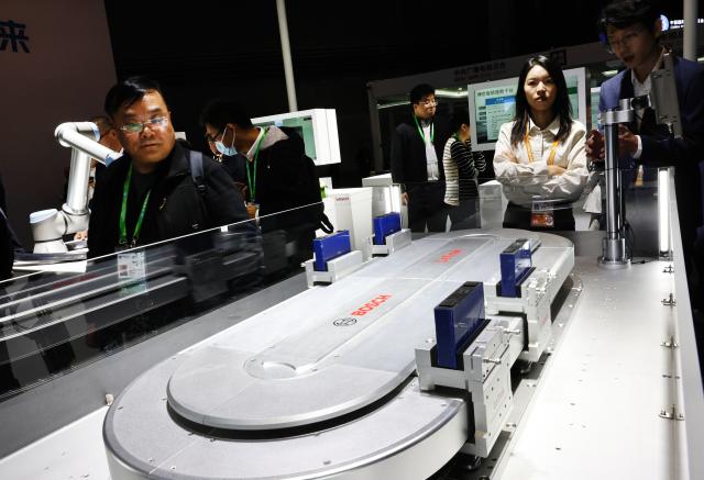 (251106) -- SHANGHAI, Nov. 6, 2025 (Xinhua) -- Visitors view LeTrak, a magnetic drive conveyance system of Bosch, which made its global debut during the 8th China International Import Expo (CIIE) in east China's Shanghai, Nov. 6, 2025. Many exhibitors showcased their latest products for the first time at the 8th CIIE in Shanghai. (Xinhua/Fang Zhe)