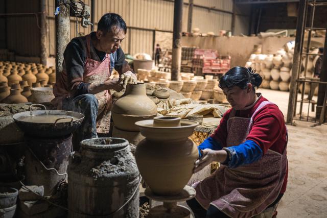 (251106) -- QUJING, Nov. 6, 2025 (Xinhua) -- Villagers make pottery products at a workshop in Liaohu Village of Qujing, southwest China's Yunnan Province, Nov. 5, 2025. Located on the bank of the Nanpan River in the city of Qujing, the Liaohu Village boasts a thousand-year pottery-making tradition. (Xinhua/Wang Guansen)