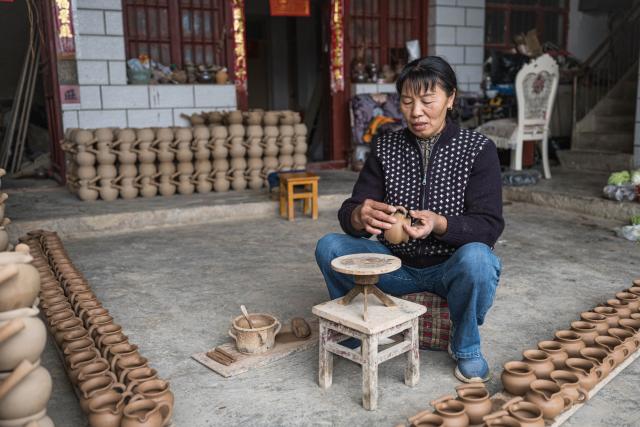 (251106) -- QUJING, Nov. 6, 2025 (Xinhua) -- A villager makes a pottery product at home in Liaohu Village of Qujing, southwest China's Yunnan Province, Nov. 5, 2025. Located on the bank of the Nanpan River in the city of Qujing, the Liaohu Village boasts a thousand-year pottery-making tradition. (Xinhua/Wang Guansen)