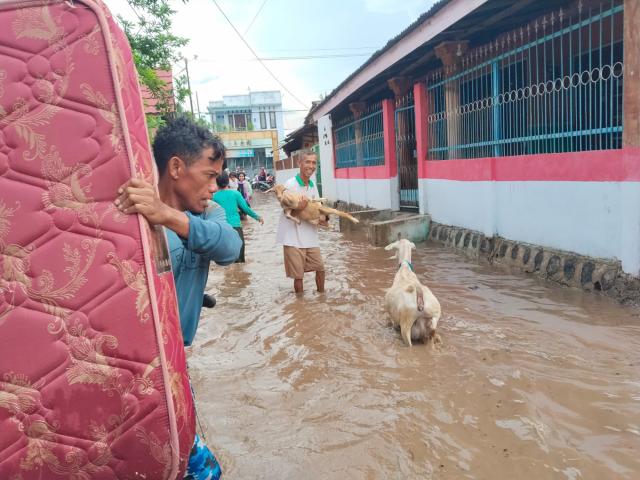 (251106) -- WEST NUSA TENGGARA, Nov. 6, 2025 (Xinhua) -- This photo provided by Indonesia's National Disaster Management Agency (BNPB) shows villagers wading through flood water after a heavy rain in Bima regency, West Nusa Tenggara, Indonesia, Nov. 5, 2025. (BNPB/Handout via Xinhua)