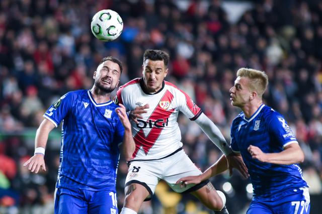 (251107) -- MADRID, Nov. 7, 2025 (Xinhua) -- Oscar Trejo (C) of Rayo Vallecano vies with Antonio Milic (L) and Mateusz Skrzypczak of Lech Poznan during the round 3 match between Rayo Vallecano and Lech Poznan at the 2025-2026 UEFA Europa Conference League in Madrid, Spain, Nov. 6, 2025. (Photo by Gustavo Valiente/Xinhua)