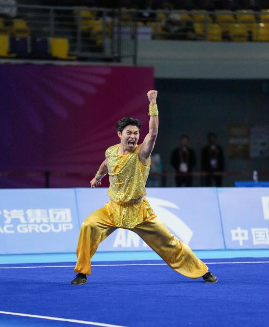 (251107) -- GUANGZHOU, Nov. 7, 2025 (Xinhua) -- Han Zemin of Guangdong competes during the men's Nanquan-Nandao-Nangun of Wushu Taolu event at China's 15th National Games in Guangzhou, south China's Guangdong Province, Nov. 7, 2025. (Xinhua/Jigme Dorji)