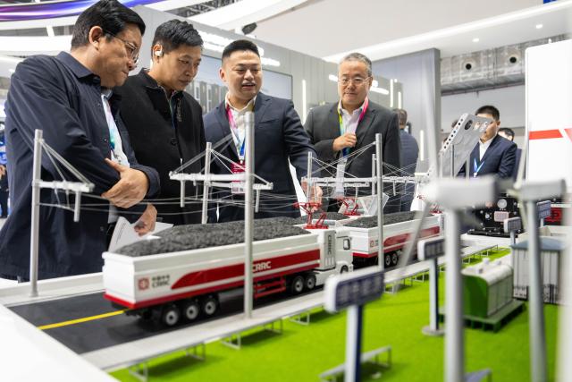 (251107) -- ZHUZHOU, Nov. 7, 2025 (Xinhua) -- An exhibitor (3rd L) introduces a system for electrified road transportation to visitors during the 2025 China International Rail Transit & Equipment Manufacturing Industry Exposition in Zhuzhou, central China's Hunan Province, Nov. 7, 2025. Boasting an exhibition area of about 40,000 square meters, the expo kicked off here on Friday, covering a wide range of fields such as rail transit and equipment manufacturing, key parts and raw materials, high-tech demonstration, intelligent systems, operation and maintaining, and infrastructure design and consultation. Magnetic levitation and other cutting-edge technologies are highlighted at this event. (Xinhua/Chen Sihan)