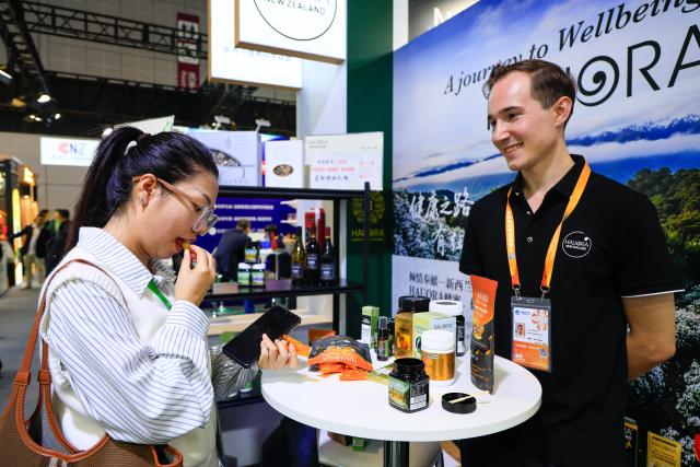 (251107) -- SHANGHAI, Nov. 7, 2025 (Xinhua) -- A visitor (L) tastes honey lozenges at the booth of a New Zealand honey brand at the Food and Agricultural Products exhibition area during the eighth China International Import Expo (CIIE) in east China's Shanghai, on Nov. 6, 2025. Manuka honey is a signature variety of New Zealand honey. Its nectar plant, the Manuka tree, is a unique species that is only found in a few countries in the Southern Hemisphere, most notably in North Island of New Zealand. The uniqueness of this honey lies in its highly nutritious contents and very limited annual yield.
    Many New Zealand companies brought the Manuka honey to the 8th China International Import Expo (CIIE). These enterprises are "old friends" of this international event and have been continuously introducing various Manuka honey and related products to the Chinese market. (Xinhua/Liu Jiaqi)