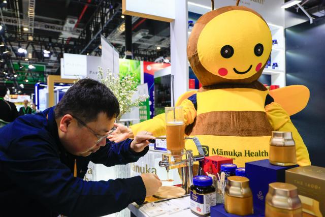 (251107) -- SHANGHAI, Nov. 7, 2025 (Xinhua) -- An exhibitor serves honey samples to visitors at the booth of a New Zealand honey brand at the Food and Agricultural Products exhibition area during the eighth China International Import Expo (CIIE) in east China's Shanghai, on Nov. 6, 2025. Manuka honey is a signature variety of New Zealand honey. Its nectar plant, the Manuka tree, is a unique species that is only found in a few countries in the Southern Hemisphere, most notably in North Island of New Zealand. The uniqueness of this honey lies in its highly nutritious contents and very limited annual yield.
    Many New Zealand companies brought the Manuka honey to the 8th China International Import Expo (CIIE). These enterprises are "old friends" of this international event and have been continuously introducing various Manuka honey and related products to the Chinese market. (Xinhua/Liu Jiaqi)