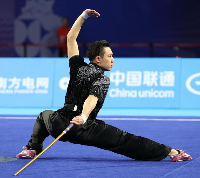 (251107) -- GUANGZHOU, Nov. 7, 2025 (Xinhua) -- Yang Yalin of Jiangsu competes during the Gunshu competition of men's Changquan-Daoshu-Gunshu of Wushu Taolu event at China's 15th National Games in Guangzhou, south China's Guangdong Province, Nov. 7, 2025. (Xinhua/Yang Shiyao)