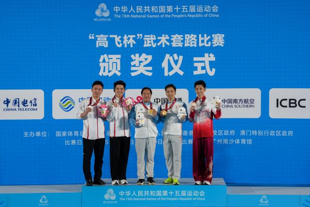 (251107) -- GUANGZHOU, Nov. 7, 2025 (Xinhua) -- Gold medalist Li Jianming (2nd R) of Beijing Sport University and his coach, silver medalist Yu Dihao (2nd L) of Yunnan and his coach, bronze medalist Yang Fuhua (R) of Guangdong pose for photos during the awarding ceremony for the men's Nanquan-Nandao-Nangun of Wushu Taolu event at China's 15th National Games in Guangzhou, south China's Guangdong Province, Nov. 7, 2025. (Xinhua/Jigme Dorji)