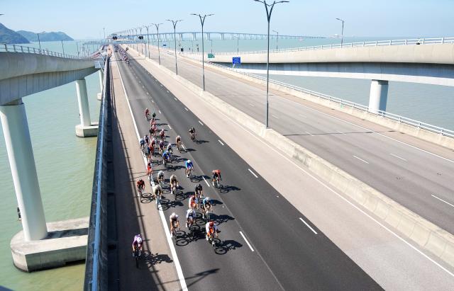 (251108) -- HONG KONG, Nov. 8, 2025 (Xinhua) -- Cyclists compete across the Hong Kong-Zhuhai-Macao Bridge during the men's road race of cycling road at China's 15th National Games in Hong Kong, south China, Nov. 8, 2025. (Xinhua/Zhu Wei)