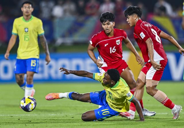 (251108) -- DOHA, Nov. 8, 2025 (Xinhua) -- Gabriel Mec (bottom) of Brazil vies with Nazriel Alvaro (1st R) of Indonesia during the group H match between Brazil and Indonesia of FIFA U17 World cup Qatar 2025 in Doha, Qatar, on Nov. 7, 2025. (Photo by Nikku/Xinhua)