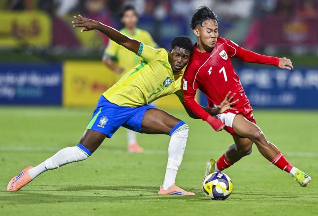(251108) -- DOHA, Nov. 8, 2025 (Xinhua) -- Ruan Pablo (L) of Brazil vies with Zahaby Gholy of Indonesia during the group H match between Brazil and Indonesia of FIFA U17 World cup Qatar 2025 in Doha, Qatar, on Nov. 7, 2025. (Photo by Nikku/Xinhua)