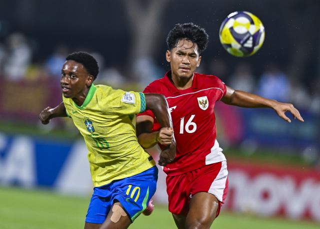 (251108) -- DOHA, Nov. 8, 2025 (Xinhua) -- Gabriel Mec (L) of Brazil vies with Muhammad Algazani of Indonesia during the group H match between Brazil and Indonesia of FIFA U17 World cup Qatar 2025 in Doha, Qatar, on Nov. 7, 2025. (Photo by Nikku/Xinhua)