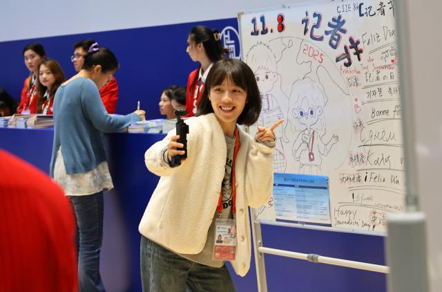 (251108) -- SHANGHAI, Nov. 8, 2025 (Xinhua) -- A journalist takes videos at the media center for the 8th China International Import Expo (CIIE) in Shanghai, east China, Nov. 8, 2025. The media center for the 8th CIIE held various events on Saturday to mark China's annual Journalists' Day, which falls on Nov. 8. (Xinhua/Fang Zhe)