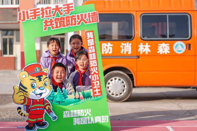 (251108) -- YINCHUAN, Nov. 8, 2025 (Xinhua) -- Students pose for a group photo during an educational activity about forest fire prevention  at a primary school in Yinchuan, northwest China's Ningxia Hui Autonomous Region, Nov. 7, 2025. Currently, the risk of forest fire is high across the Helan Mountain. Staff members of local nature reserve administration have rolled out a series of educational activities with the theme of forest fire prevention, aiming to enhance students' safety awareness via lectures, equipment demonstrations, and hands-on experiences. (Xinhua/Yang Zhisen)