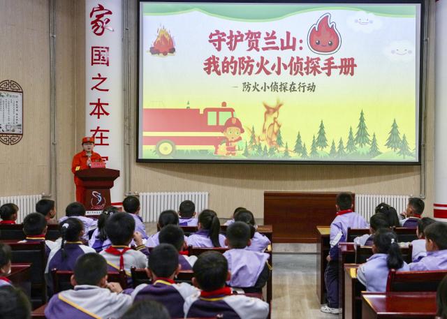 (251108) -- YINCHUAN, Nov. 8, 2025 (Xinhua) -- A staff member of Ningxia Helan Mountain National Nature Reserve Administration gives a lecture on forest fire prevention at a primary school in Yinchuan, northwest China's Ningxia Hui Autonomous Region, Nov. 7, 2025. Currently, the risk of forest fire is high across the Helan Mountain. Staff members of local nature reserve administration have rolled out a series of educational activities with the theme of forest fire prevention, aiming to enhance students' safety awareness via lectures, equipment demonstrations, and hands-on experiences. (Xinhua/Yang Zhisen)