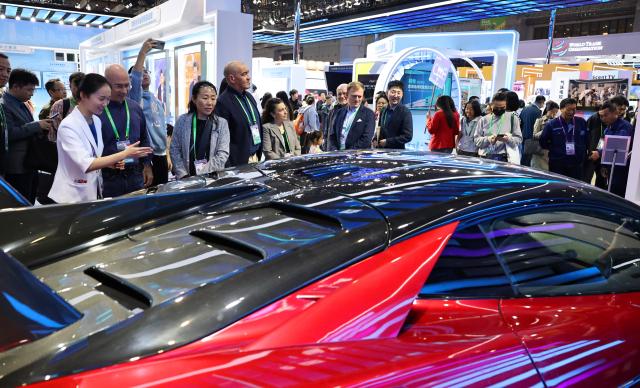 (251108) -- SHANGHAI, Nov. 8, 2025 (Xinhua) -- Guests view a new energy vehicle (NEV) of BYD, China's leading NEV manufacturer, at the China Pavilion during the eighth China International Import Expo (CIIE) in east China's Shanghai, Nov. 8, 2025. Over 30 foreign talents and their families were invited to visit the eighth CIIE at the National Convention and Exhibition Center (Shanghai) during a themed event on Saturday. (Xinhua/Fang Zhe)